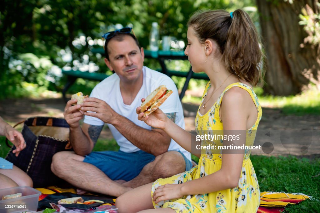 Familie genießt im Sommer ein Picknick im öffentlichen Park.
