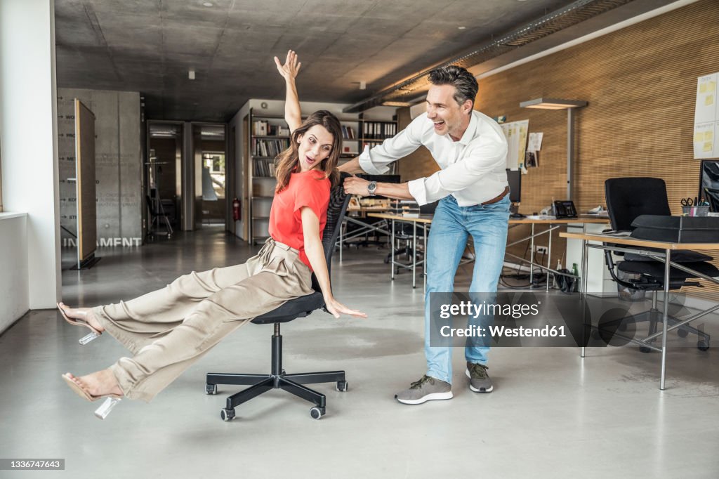 Male and female colleague having fun while playing in office