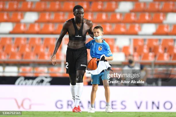 Pitch invader is seen with Mouctar Diakhaby of Valencia CF after the La Liga Santander match between Valencia CF and Deportivo Alaves at Estadio...