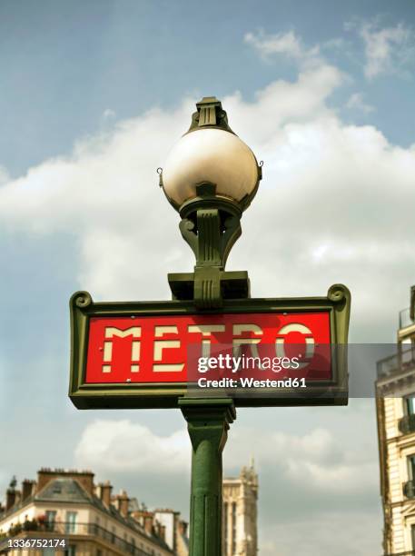 metro signboard on lamppost in city - paris metro sign stockfoto's en -beelden