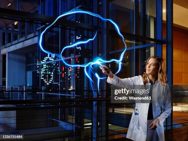 female neurologist analyzing brain with light painting at hospital - 神経科医 ストックフォトと画像