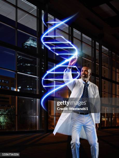 mature male doctor analyzing dna in laboratory at hospital - dna spiral stock pictures, royalty-free photos & images