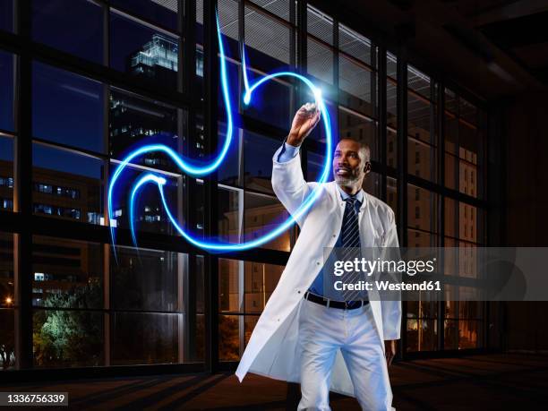 male gastroenterologist light painting stomach in laboratory at hospital - male stomach stock-fotos und bilder