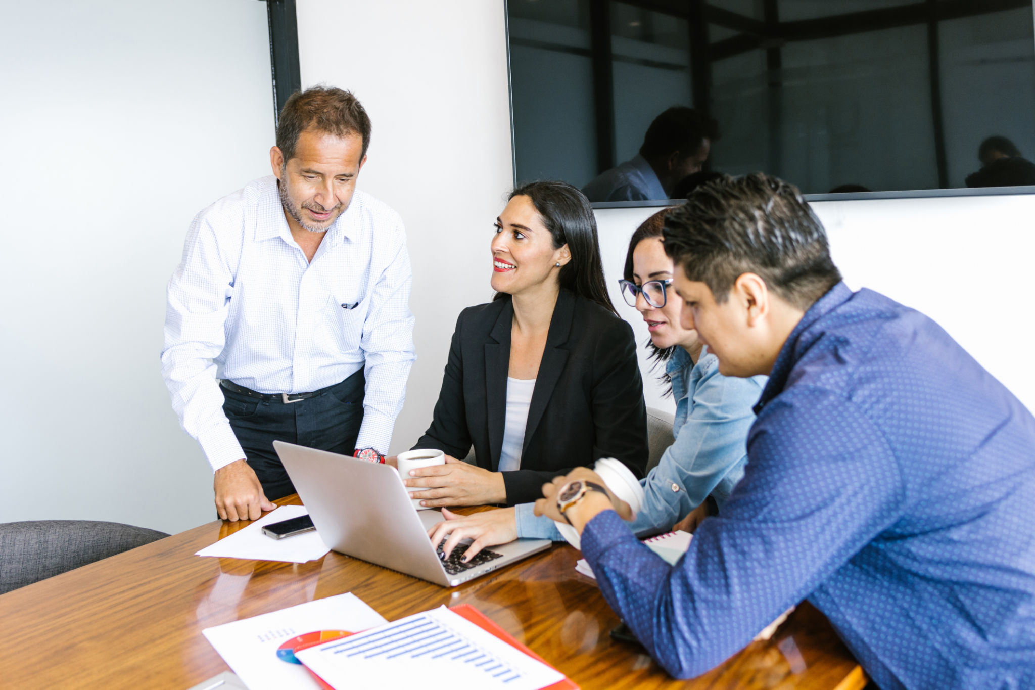 Latin business people with computer collaborating on project in the office in Latin America Latin business people with computer collaborating on project in the office in Latin America