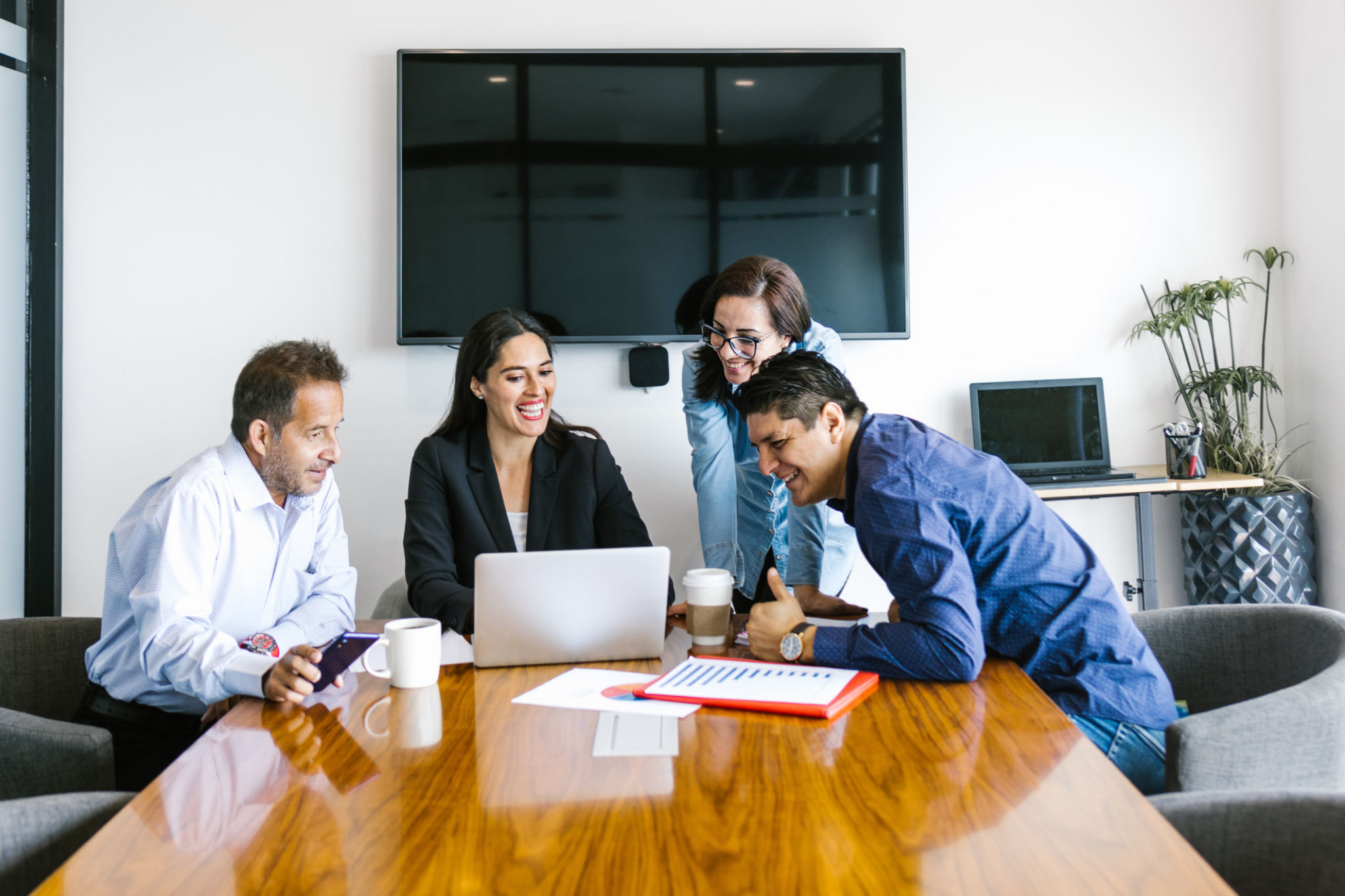 Group of hispanic people doing teamwork in office using digital devices in Latin America Group of hispanic people doing teamwork in office using digital devices in Latin America