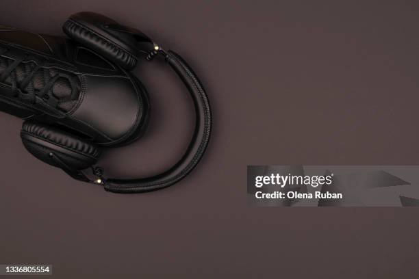black sneakers and headphones on black desk - smart shoes stock pictures, royalty-free photos & images