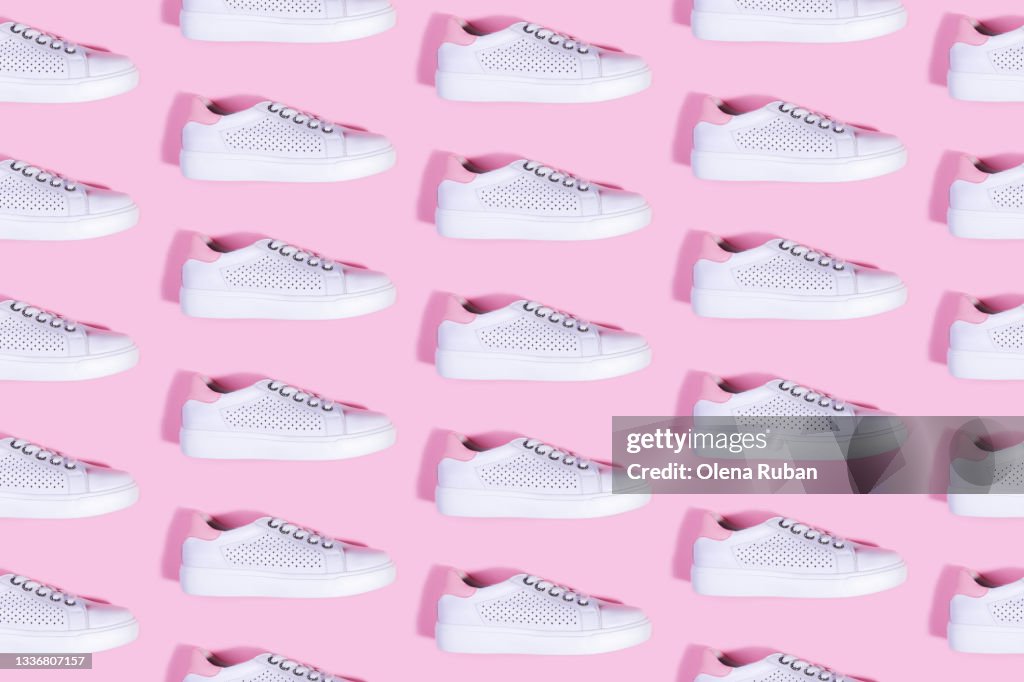 Many white sneakers on pink background pattern