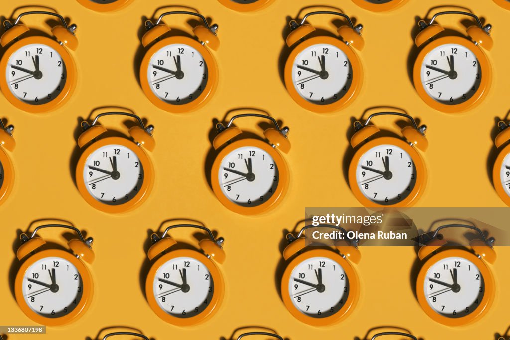 Bright alarm clocks on orange background