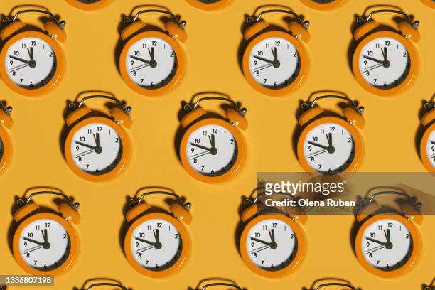bright alarm clocks on orange background - giorno foto e immagini stock