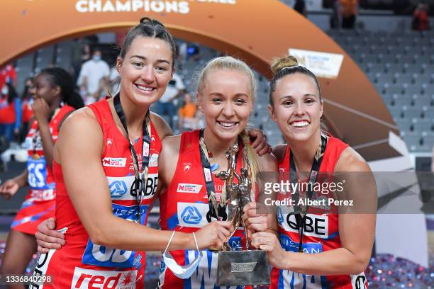 Swifts players Lauren Moore, Tayla Fraser and Paige Hadley pose with the trophy after their victory during the 2021 Super Netball Grand Final match...