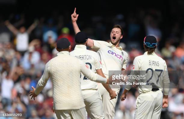 England bowler Ollie Robinson celebrates with team mates after taking the wicket of Virat Kohli during day four of the Third Test Match between...