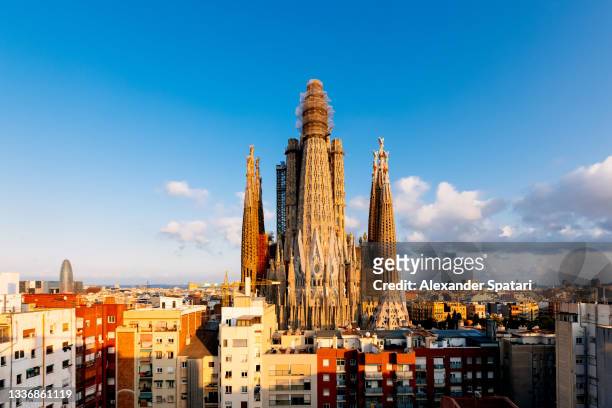 sagrada familia and barcelona skyline on a sunny day with clear blue sky, catalonia, spain - sagrada familia foto e immagini stock