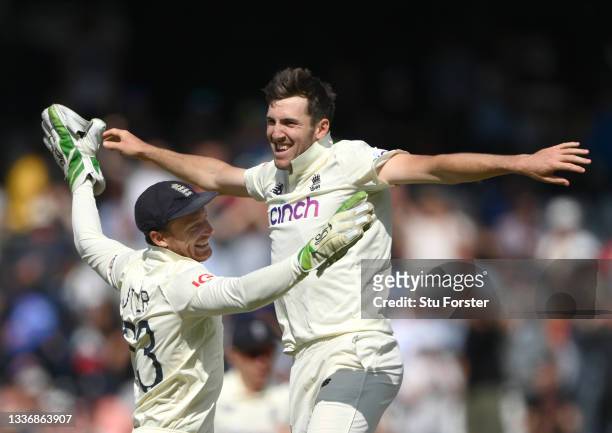 England bowler Craig Overton is congratulated by Jos Buttler after taking the final wicket of the innings, Mohammed Siraj during day four of the...