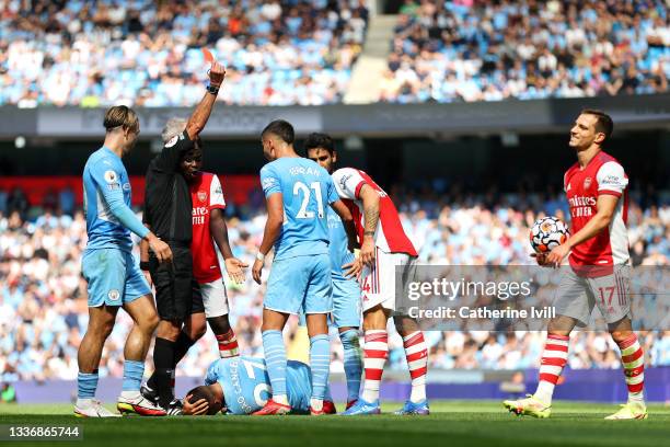 Referee Martin Atkinson awards Granit Xhaka of Arsenal a red card during the Premier League match between Manchester City and Arsenal at Etihad...