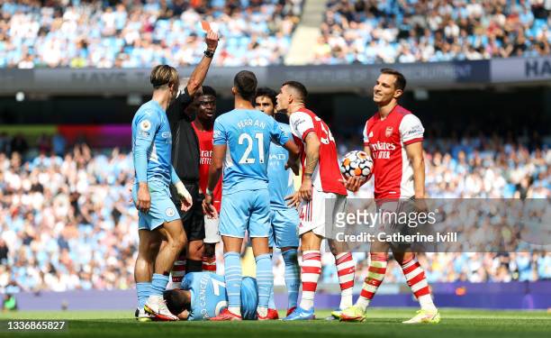 Referee Martin Atkinson awards Granit Xhaka of Arsenal a red card during the Premier League match between Manchester City and Arsenal at Etihad...