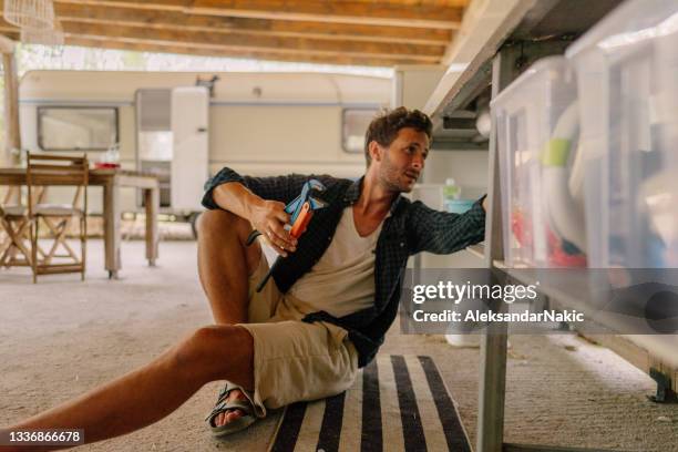 young man fixing kitchen sink - broken pipe stockfoto's en -beelden