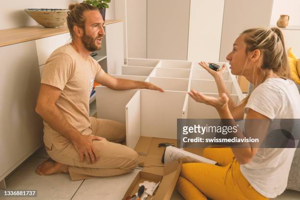 couple having argument whilst putting together self assembly furniture - model kit stock pictures, royalty-free photos & images