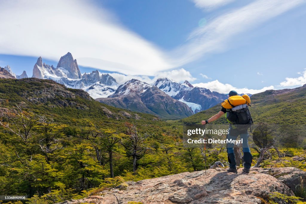 Man with backpack standing on the rock with view to mount Fitz Roy in Patagonia