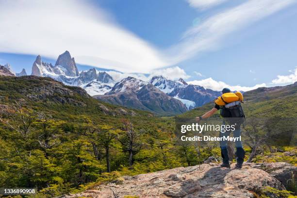 man with backpack standing on the rock with view to mount fitz roy in patagonia - santa cruz province argentina stock pictures, royalty-free photos & images