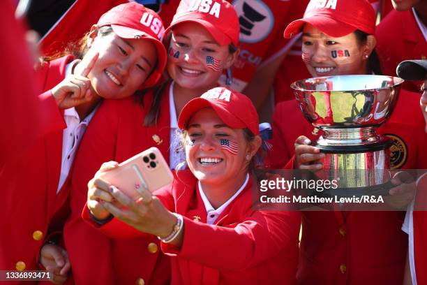 Rachel Kuehn of Team USA takes a selfie with Team USA and the Curtis Cup trophy after victory against Team Great Britain and Ireland during day three...