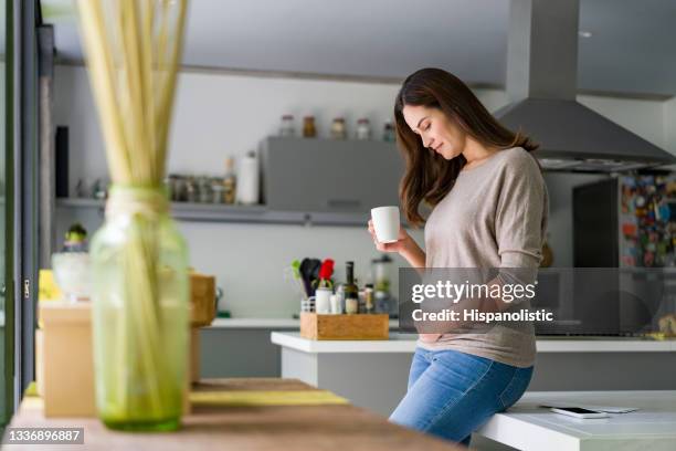 pregnant woman at home drinking a cup of coffee - pregnant coffee 個照片及圖片檔