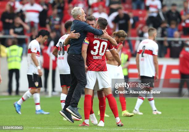 Christian Streich, Head Coach of Sport-Club Freiburg interacts with Christian Guenter of Sport-Club Freiburg following the Bundesliga match between...