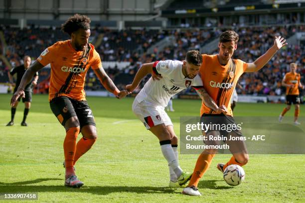 Emiliano Marcondes of Bournemouth is closed down by Tom Huddlestone and Jacob Greaves of Hull City during the Sky Bet Championship match between Hull...