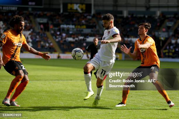 Emiliano Marcondes of Bournemouth is closed down by Tom Huddlestone and Jacob Greaves of Hull City during the Sky Bet Championship match between Hull...