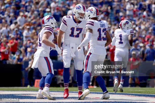 Cole Beasley, Josh Allen, and Gabriel Davis, all of the Buffalo Bills, celebrate after scoring a touchdown during the first quarter against the Green...