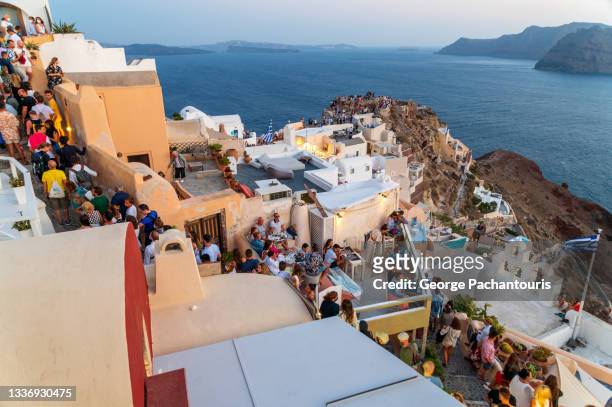 tourists watching the sunset in oia, santorini, greece - fira santorini stock pictures, royalty-free photos & images