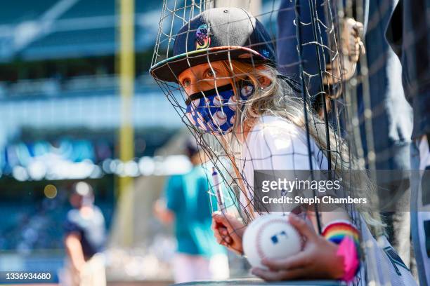 Young fan reaches her baseball out to players for an autograph before the game against the Kansas City Royals at T-Mobile Park on August 28, 2021 in...