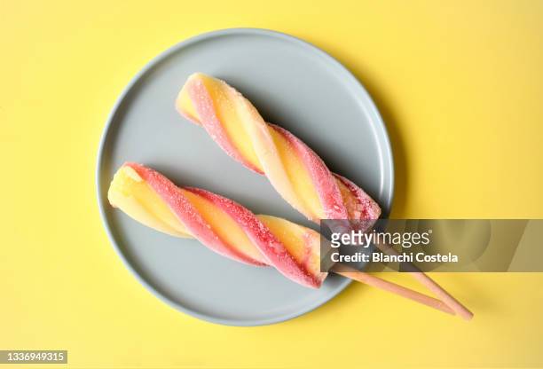 colorful popsicles on a plate in yellow background - lollipop fotografías e imágenes de stock