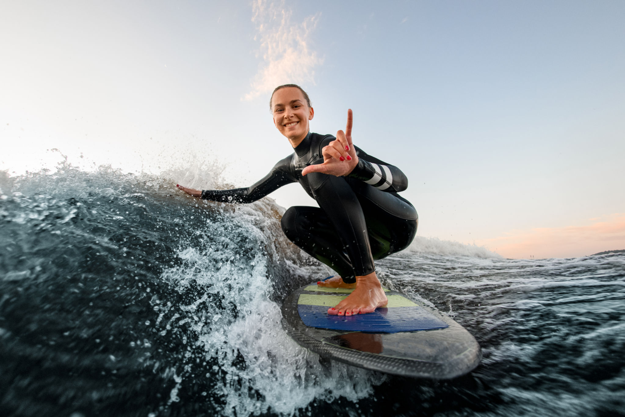 man instructor demonstrating how to stand up on surfboard to indian woman in surf class in Goa sea man instructor demonstrating how to stand up on surfboard to indian woman in surf class in Goa sea