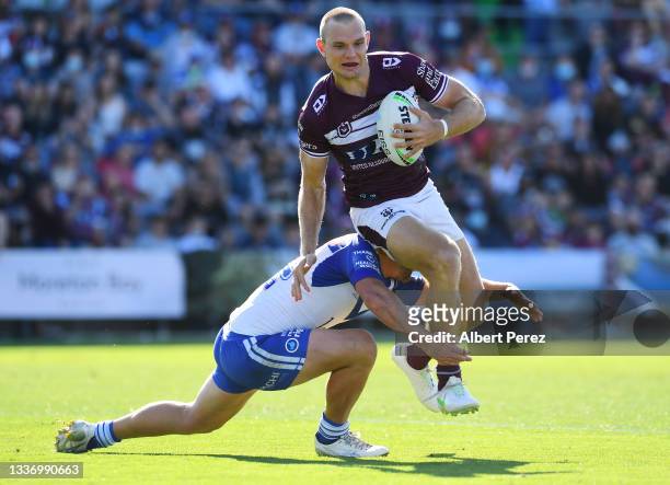 Tom Trbojevic of the Sea Eagles is tackled during the round 24 NRL match between the Manly Sea Eagles and the Canterbury Bulldogs at Moreton Daily...