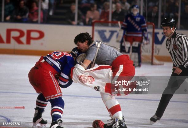 Tie Domi of the New York Rangers fights with Bob Probert of the Detroit Red Wings on February 9, 1992 at the Madison Square Garden in New York, New...