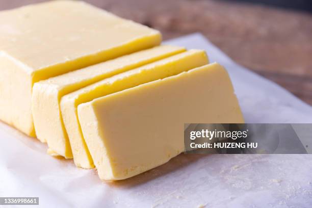 fresh butter sliced on a wooden table selective focus - knife block stock-fotos und bilder