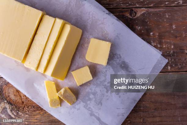 fresh butter sliced on a wooden table selective focus, top view - knife block stock-fotos und bilder