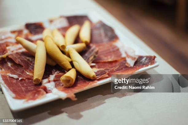 jamón ibérico and breadsticks, tapas dish served at a bar in madrid - madrid tapas stock pictures, royalty-free photos & images