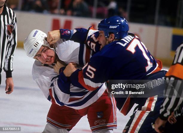 Darren Langdon of the New York Rangers fights with Brett Lindros of the New York Islanders during their game circa 1995 at the Madison Square Garden...