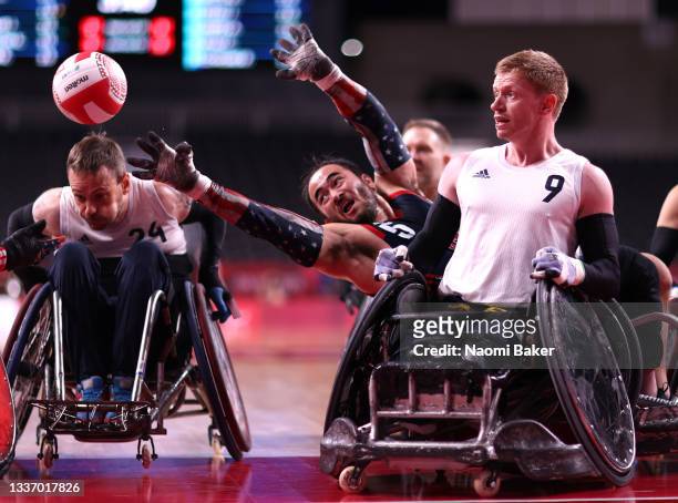 Charles Aoki of Team United States passes the ball against Jim Roberts of Team Great Britain during the gold medal wheelchair rugby match on day 5 of...