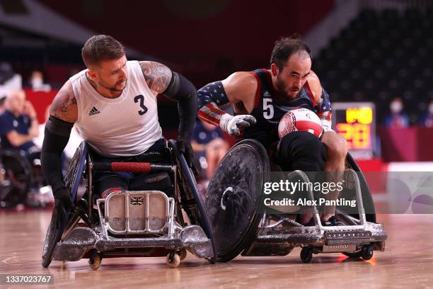 Charles Aoki of Team United States controls the ball against Stuart Robinson of Team Great Britain during the gold medal wheelchair rugby match on...