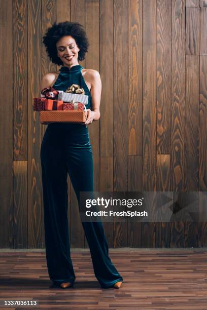 bela mulher afro-americana segurando presentes de natal (fundo marrom) - blue jumpsuit - fotografias e filmes do acervo