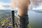 Aerial view of coal power plant high pipes with black smokestack polluting atmosphere. Electricity production with fossil fuel concept.