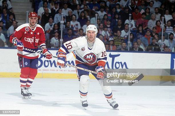 Claude Loiselle of the New York Islanders skates on the ice as Todd Krygier of the Washington Capitals follows behind during the 1993 Division Semi...