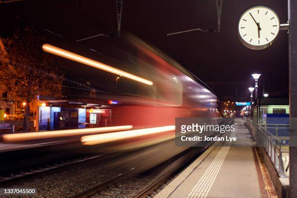 train on railroad station platform at night - switzerland train stock pictures, royalty-free photos & images