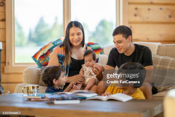 young indigenous canadian family spending time together at home - canada stock pictures, royalty-free photos & images