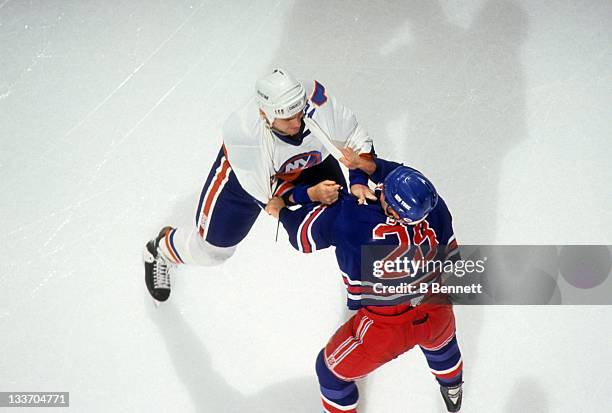 Mick Vukota of the New York Islanders fights with Tie Domi of the New York Rangers during a preseason game in September, 1992 at the Nassau Coliseum...