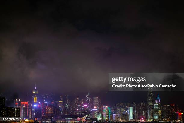 view of illuminated cityscape with skyscraper near victoria harbour in hong kong - central plaza hong kong stock-fotos und bilder