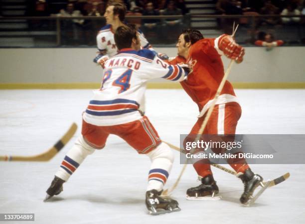 Marcel Dionne of the Detroit Red Wings tries to get around a check by Ab DeMarco of the New York Rangers circa 1972 at the Madison Square Garden in...