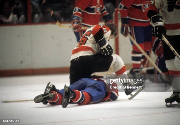 Bobby Clarke of the Philadelphia Flyers sits on Mario Tremblay of the Montreal Canadiens during their game circa 1975 at the Spectrum in...